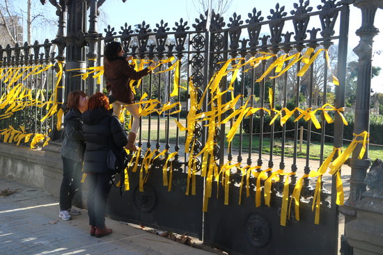 Imatge d'assistents lligant llaços grocs al perímetre del parc de la Ciutadella