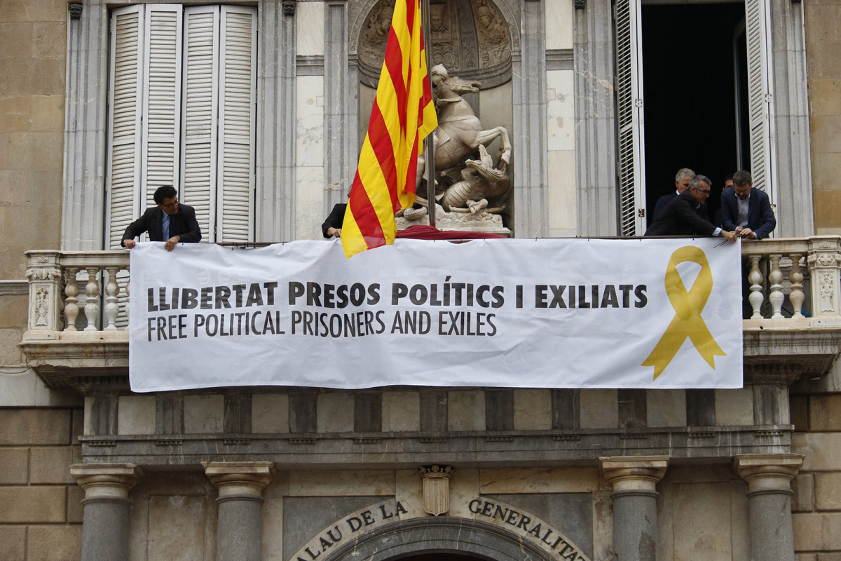 Pla mig del balcó del Palau de la Generalitat en el moment de penjar la pancarta amb el llaç groc el 2 de juny de 2018