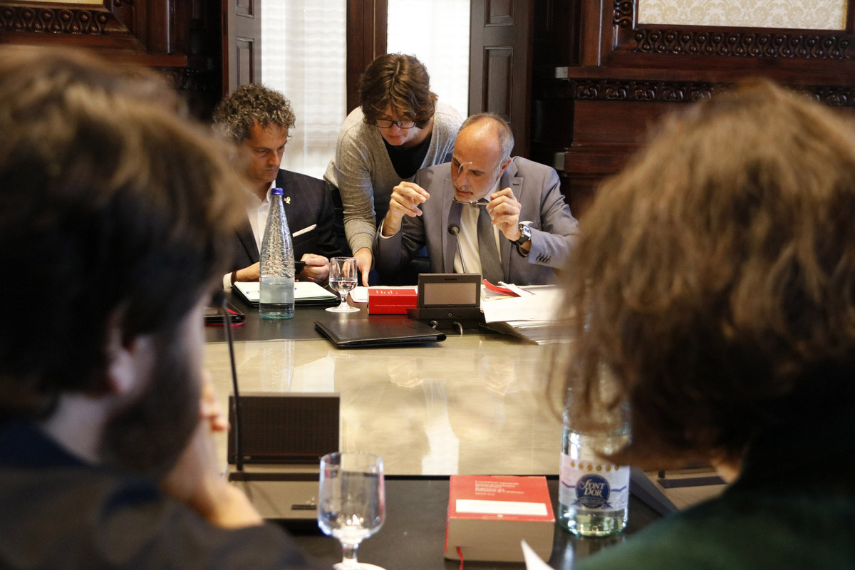 El lletrat major del Parlament, Joan Ridao, repassant papers en segon pla amb els diputats del PSC Ferran Pedret i Eva Granados en primer pla en una reunió de la Junta de Portaveus
