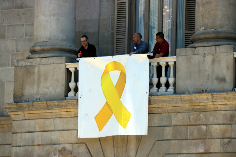 Operaris de l'Ajuntament de Barcelona col·loquen el llaç groc després de la decisió presa a la primera reunió de grups municipals