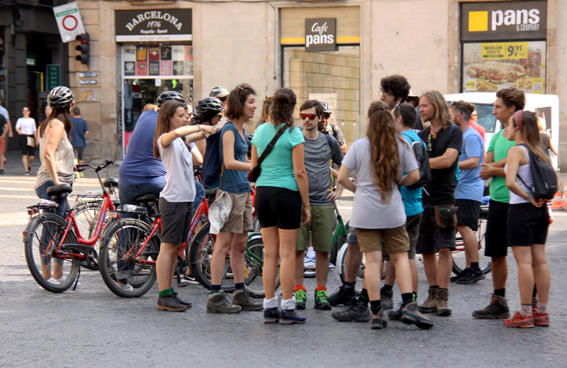 Un grup de turistes amb bicicletes a la Plaça Sant Jaume de Barcelona