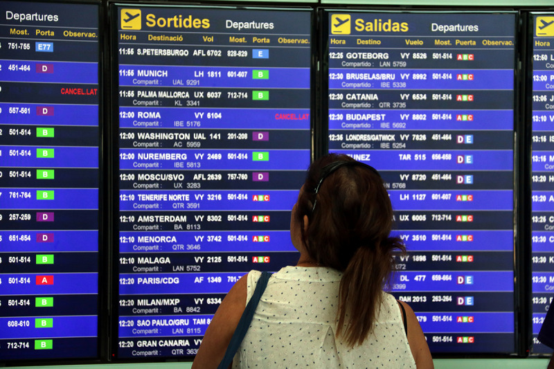 Una usuària de l'aeroport del Prat observant la pantalla de vols
