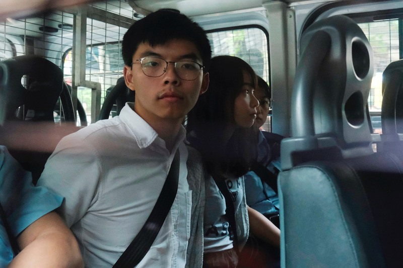 Els activistes pro-democràcia Joshua Wong i Agnes Chow arriben a una seu judicial amb un furgó policial després de ser arrestats