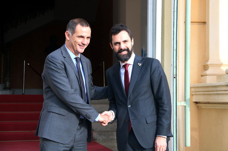 Imatge de Roger Torrent i Gilles Simeoni saludant-se a l'entrada de la seu del Consell Executiu de Còrsega