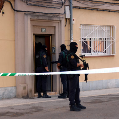 Agents de la Guàrdia Civil a la porta d'un habitatge del carrer Goya de Sabadell on estan duent a terme un escorcoll