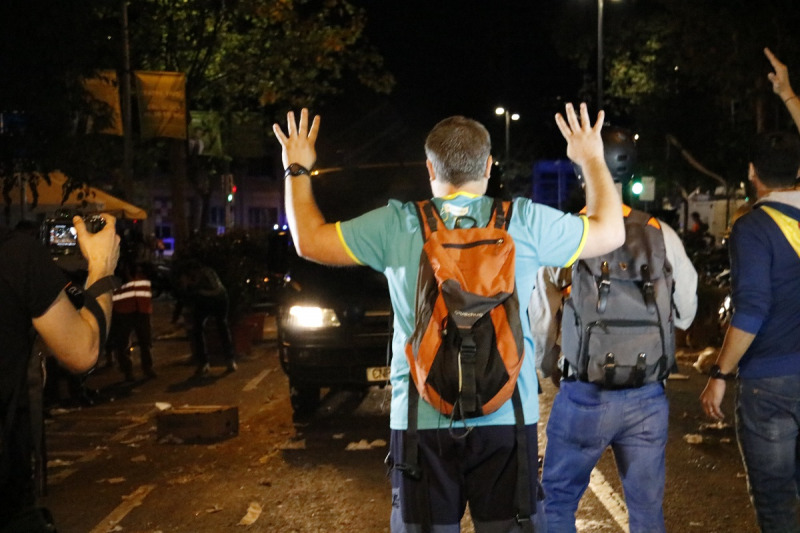 Un manifestant aixeca els braços davant de furgonetes policials el 16 d'octubre del 2019 a Barcelona