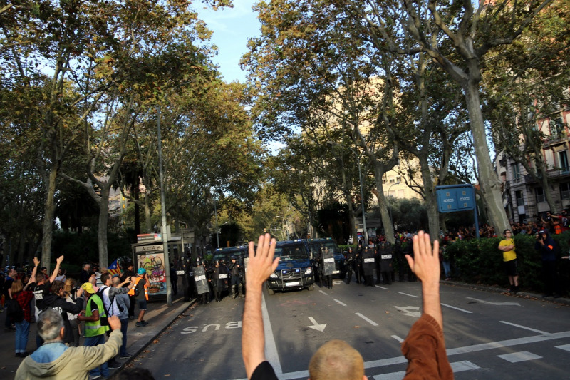 Manifestants amb els braços alçats abans que la policia espanyola inicï les primeres càrregues el 19 d'octubre
