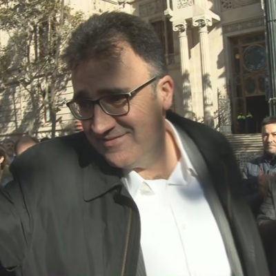Pla curt, extret d'imatge de vídeo, de Josep Lluís Salvadó, saludat per companys davant del TSJC