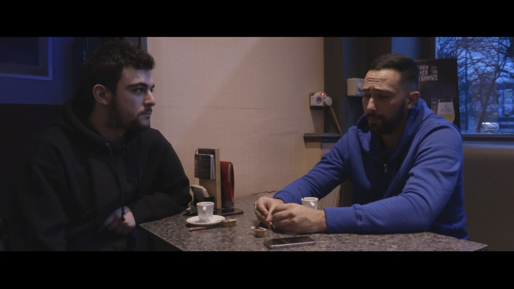 Un fotograma del documental amb Adrià Carrasco compartint taula amb el raper Valtònyc.