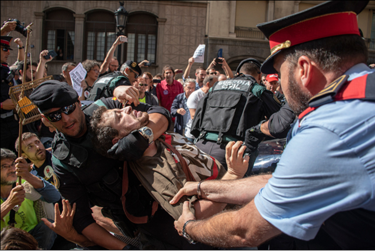 Foto: @marcpuigperez Foto de setembre 2017 a Via Laietana que mostra un mosso en defensa de la seva gent davant la policia repressora